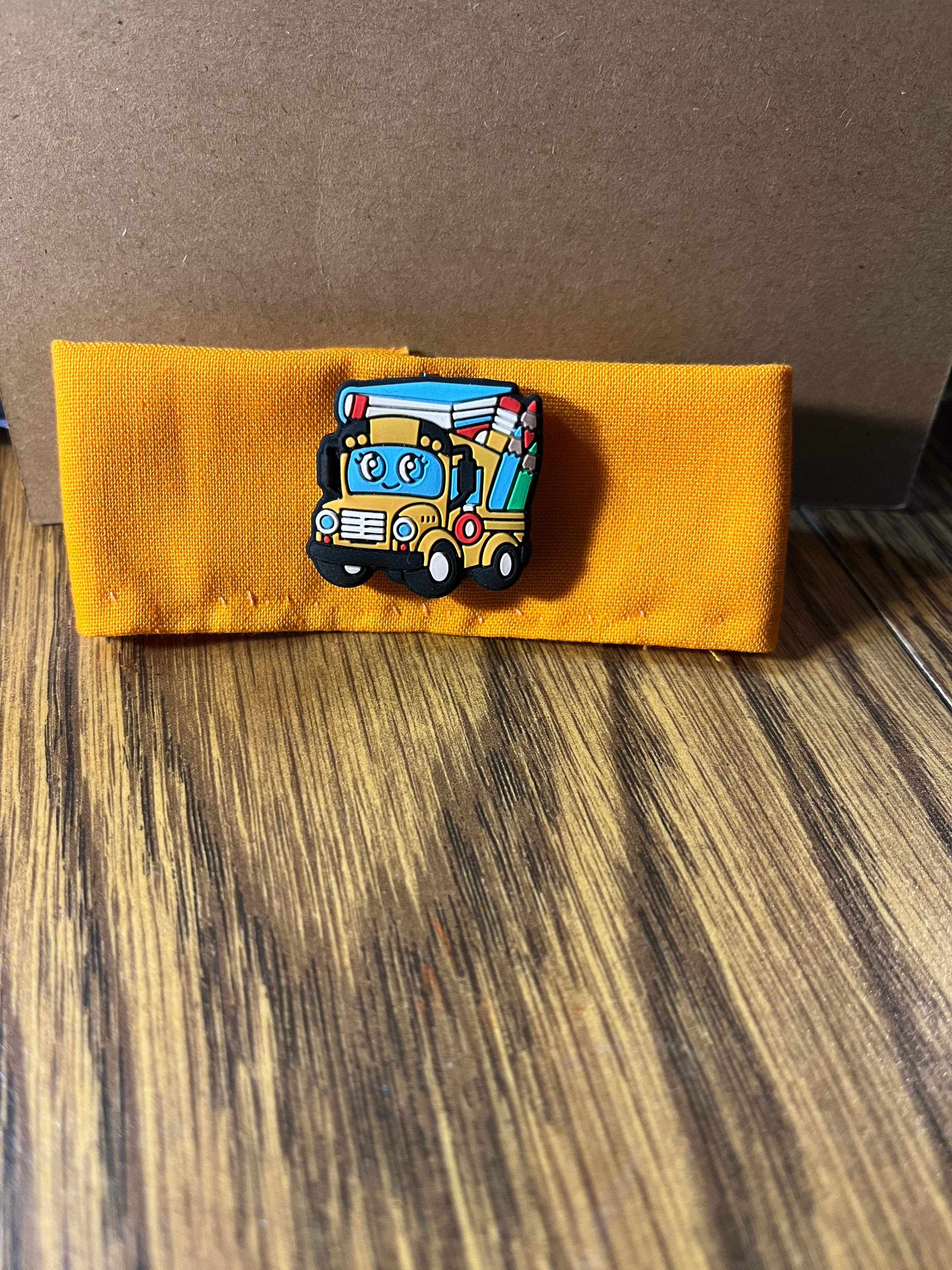 Wheels on the Bus golden yellow wrist wrap folded showing school bus charm