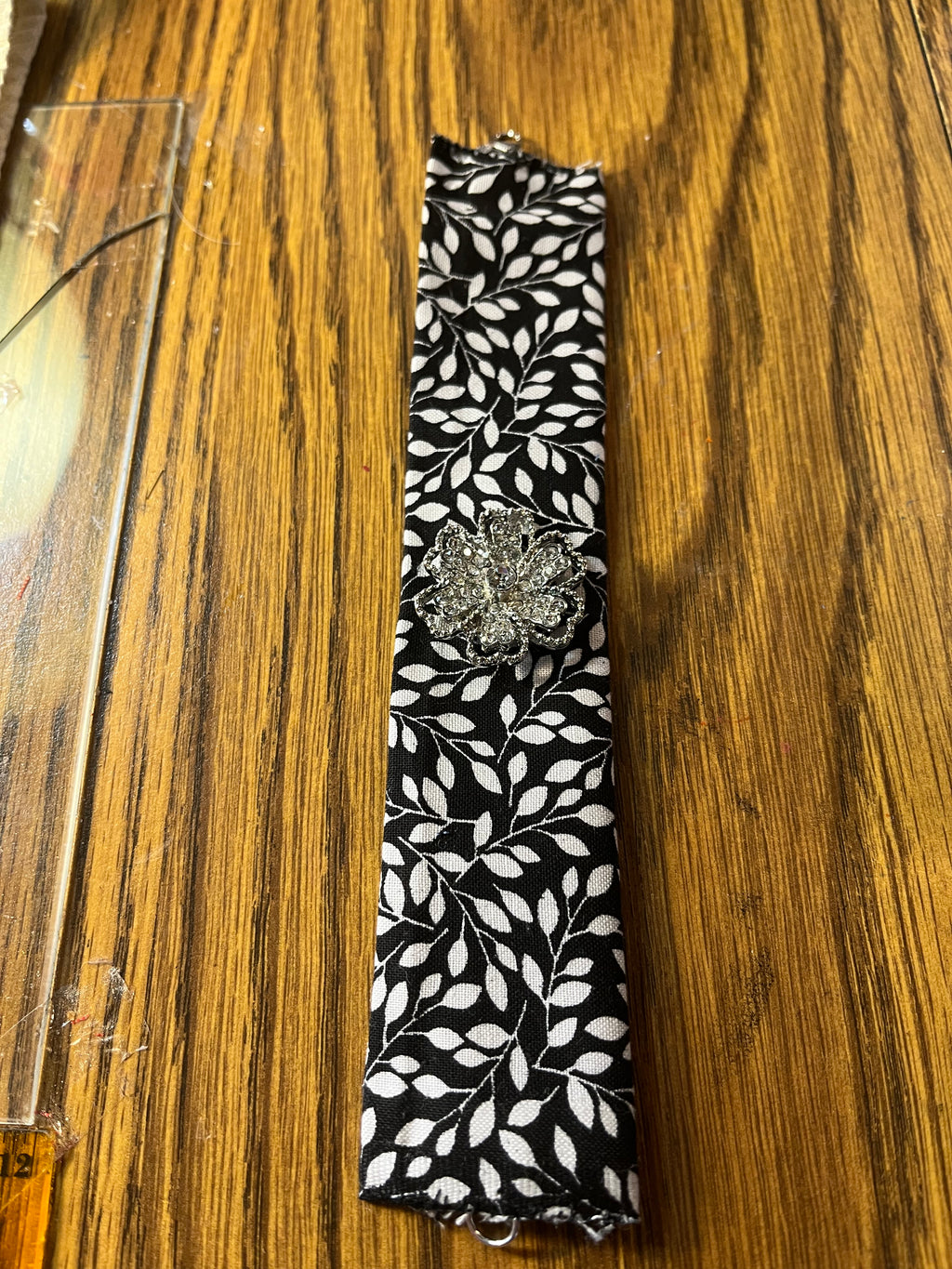 Shimmer & Shine black leaf print wrist wrap full length showing silver lobster clasp