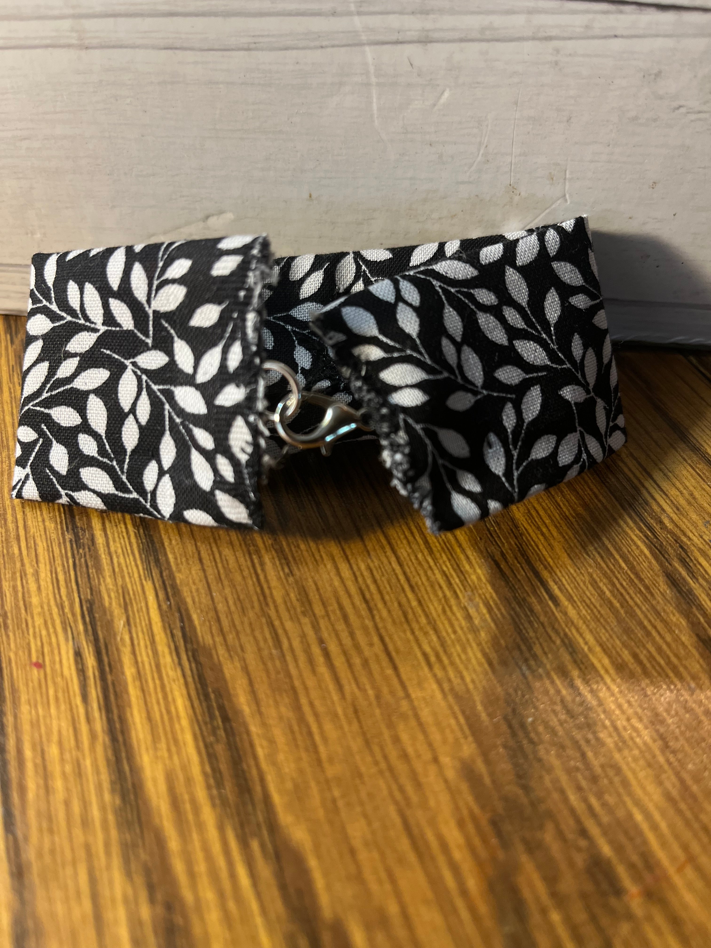 Shimmer & Shine black leaf print wrist wrap close-up showing silver lobster clasp closure