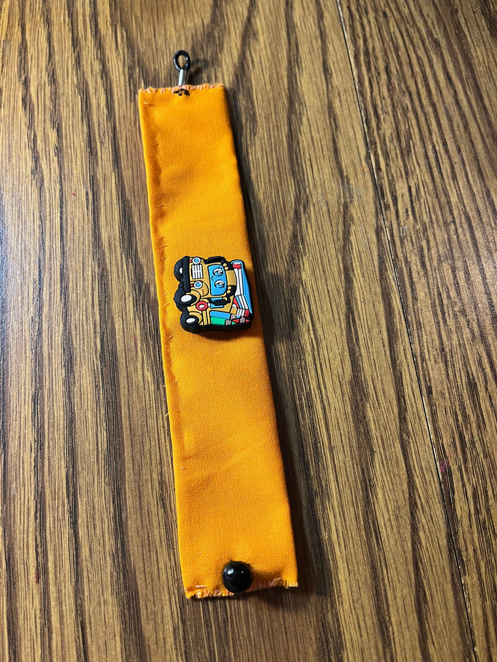 Wheels on the Bus golden yellow wrist wrap full length showing black snap closure and lobster clasp