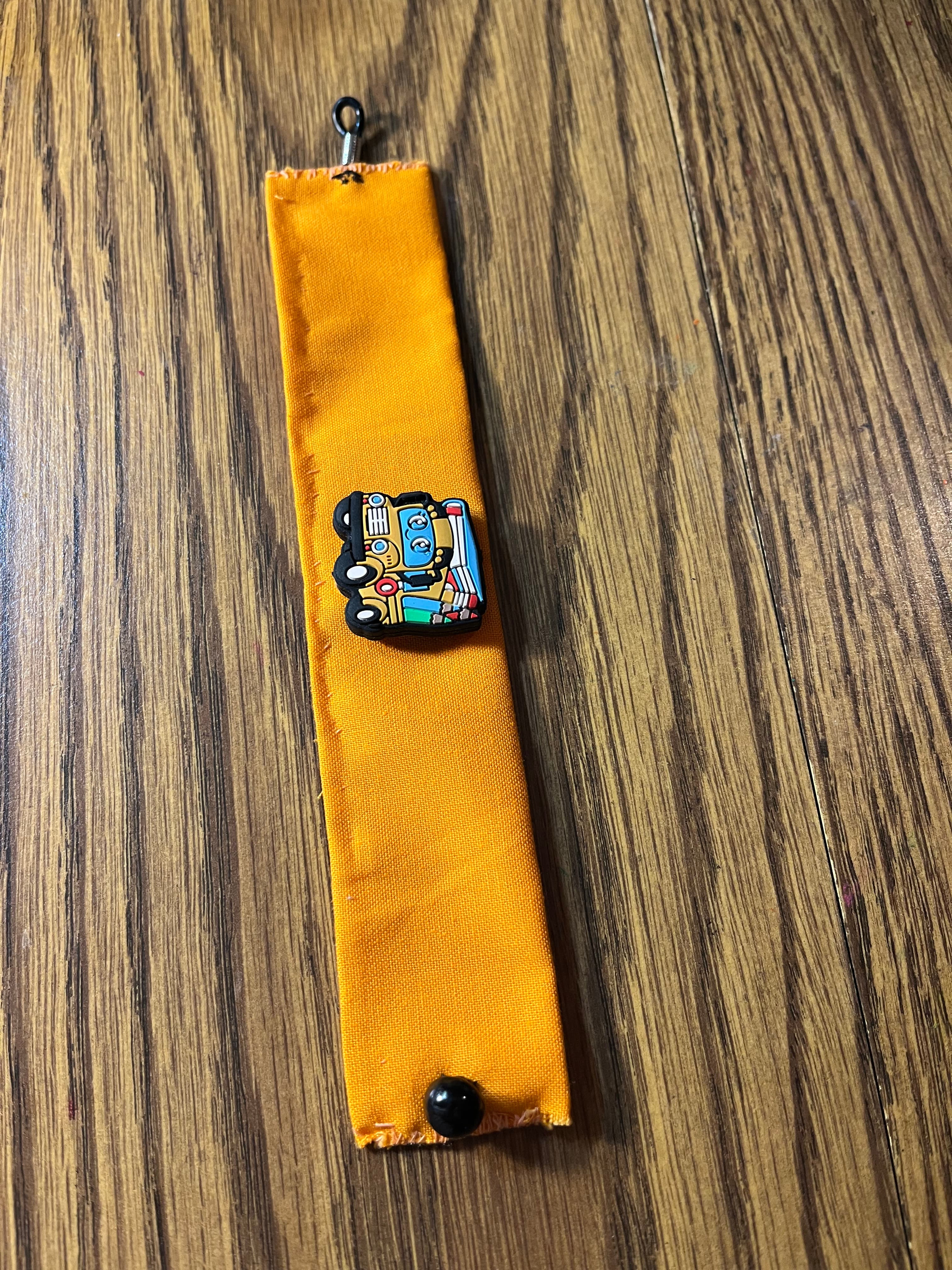 Wheels on the Bus golden yellow wrist wrap full length showing black snap closure and lobster clasp