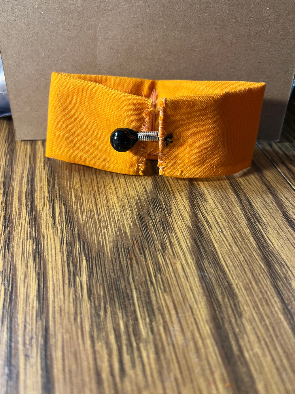 Wheels on the Bus golden yellow wrist wrap close-up showing black snap button closure