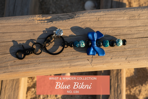 Blue Bikini beaded keychain with cobalt blue bow and teal marbled beads on driftwood surface