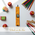 Golden yellow wrist wrap with school bus charm on bright white surface with school accents