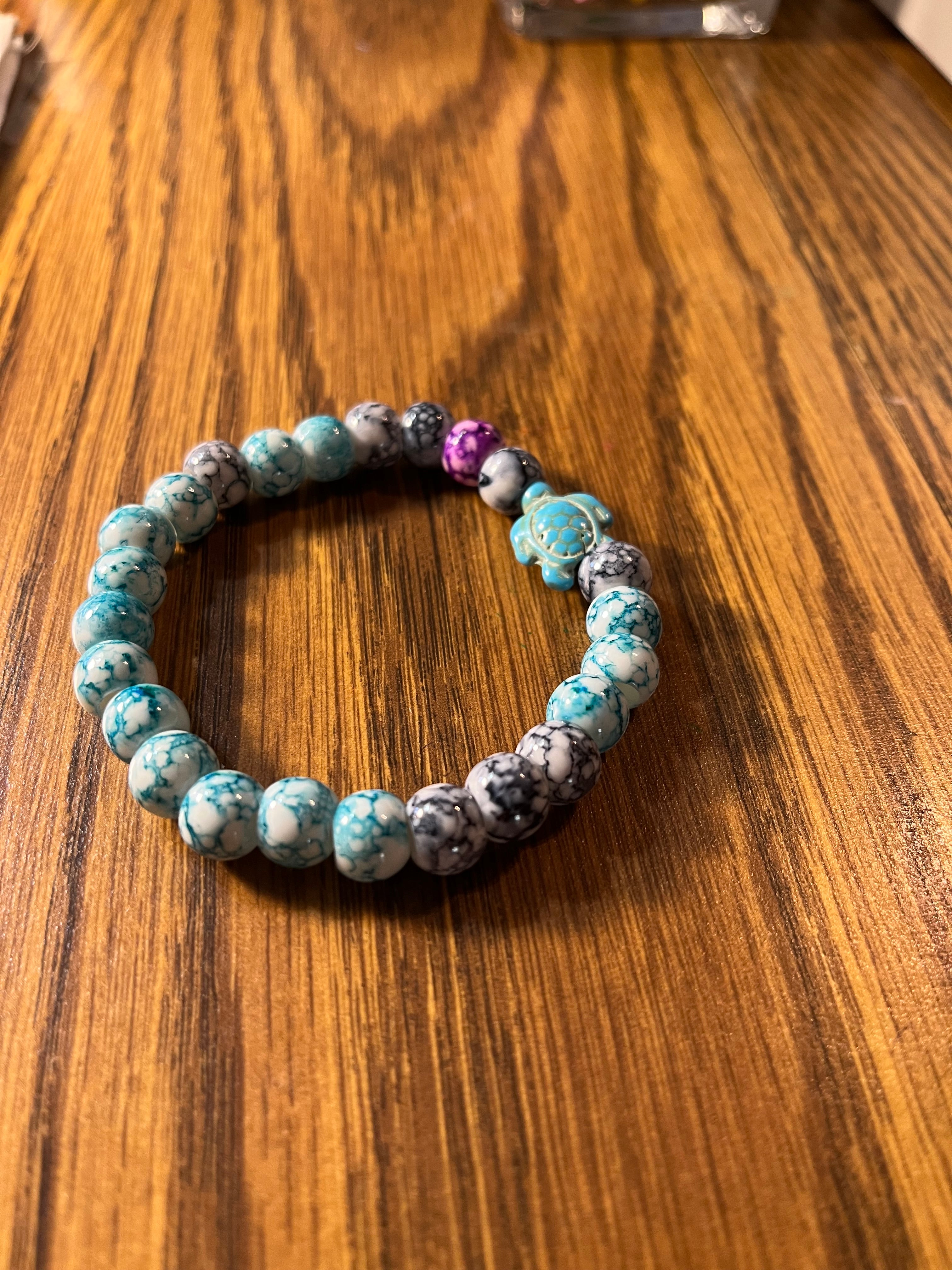 Turtle Tide teal marbled bracelet showing sea turtle charm from above